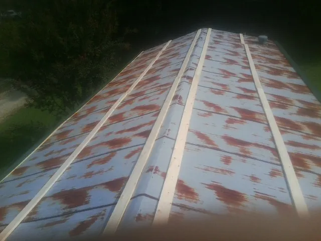 Rusted metal roof panels with new wood purlins before replacement — Storm Damage Roof Repair in Ankeny by Roofing Brothers