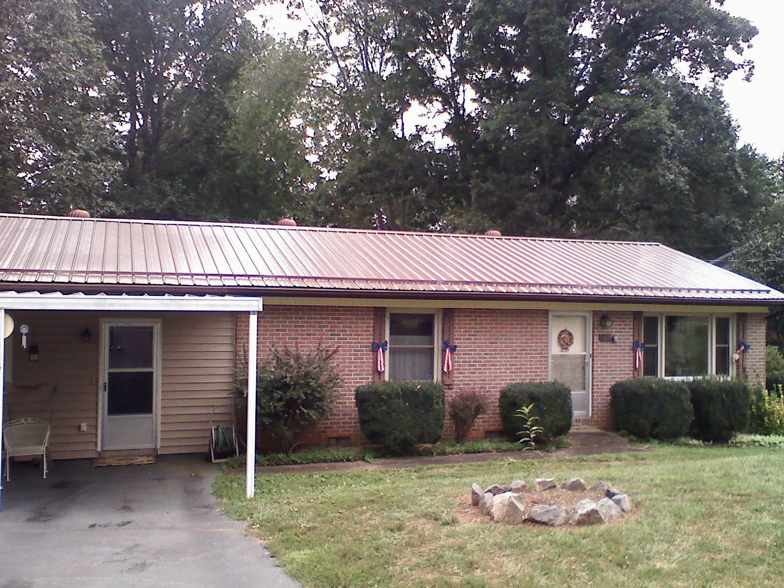 Bronze metal roof and carport on a brick ranch home — Roof Repair work by our crew in Ankeny